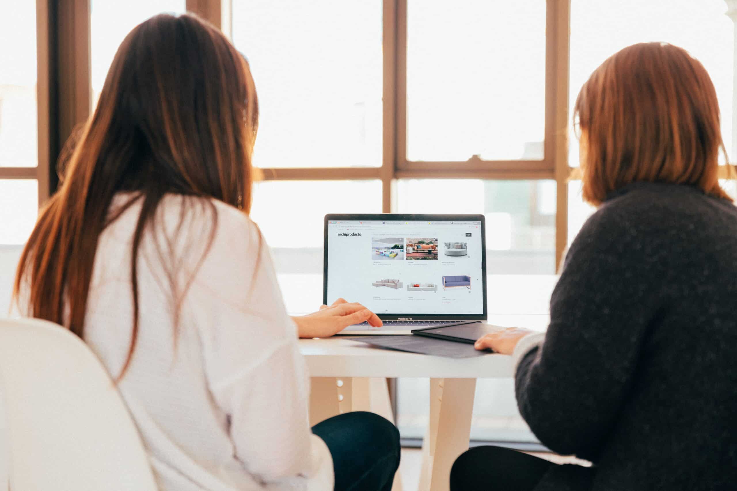 two woman working on a computer scaled